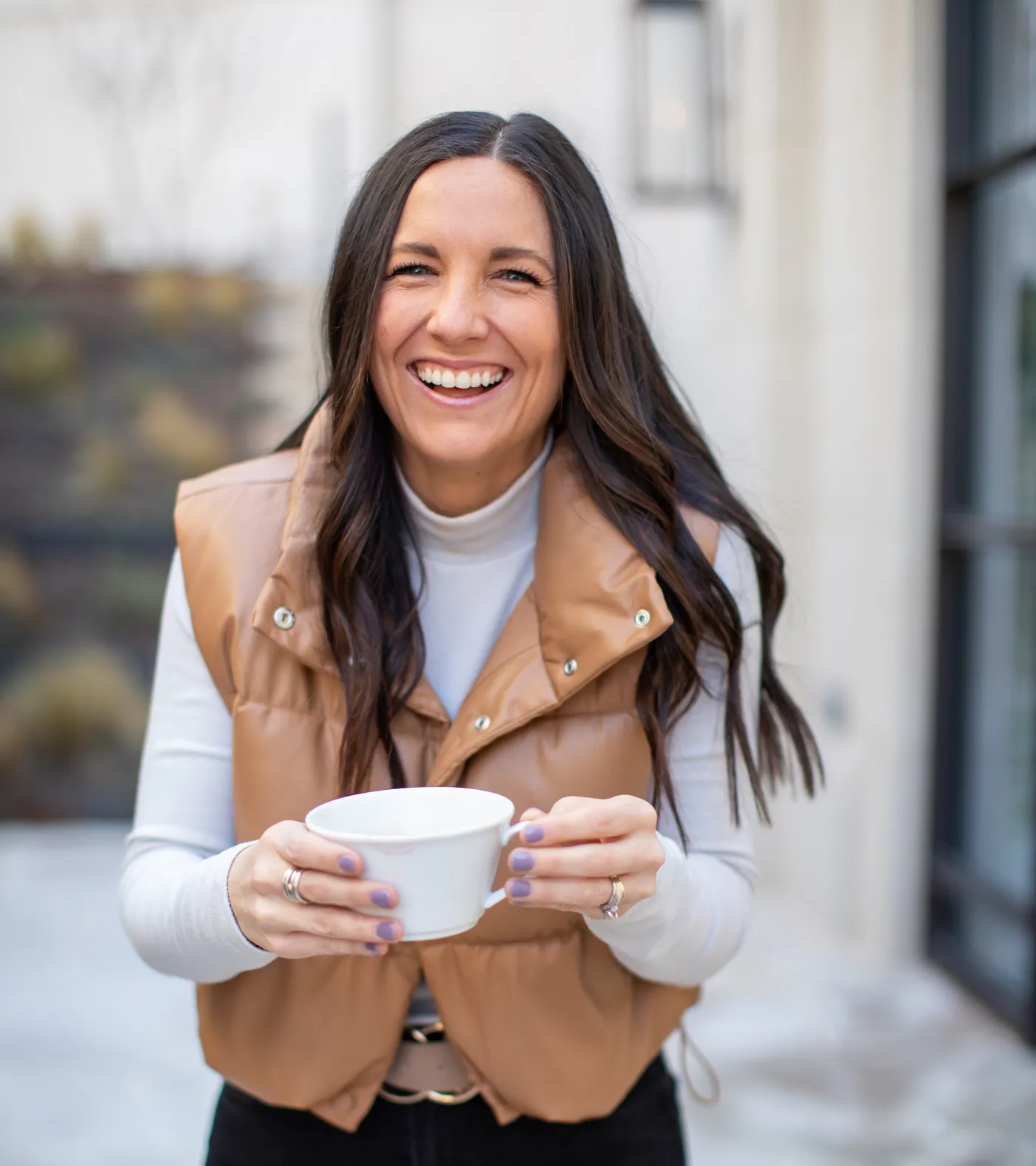Mallory Robinson laughing, holding a coffee cup